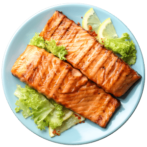 Grilled salmon fillets served on a blue plate with lettuce and lemon wedges